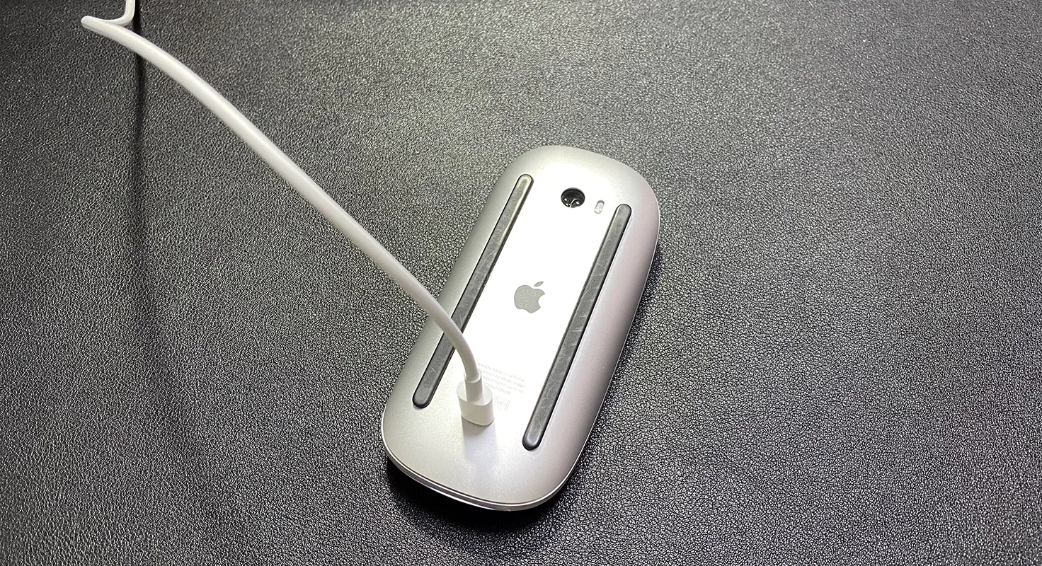 Magic Mouse 2を充電している様子。ひっくり返してライトニングケーブルをマウスの裏側にぶっさしている姿が滑稽。